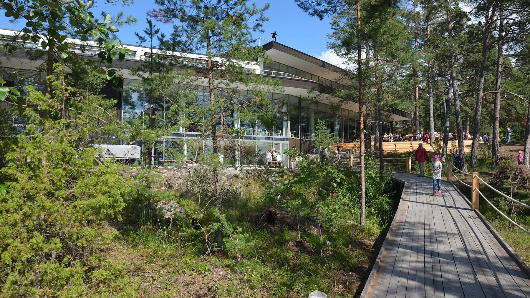 Artipelags moderna arkitektur bland tallar vid strandpromenaden